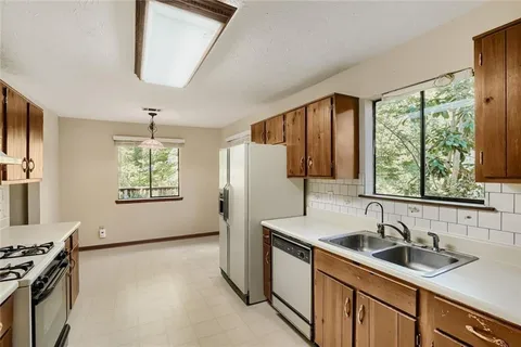 a kitchen with a sink a stove and a refrigerator