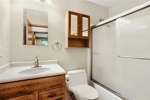 a bathroom with a sink toilet and mirror