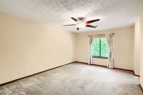 an empty room with a ceiling fan and a window