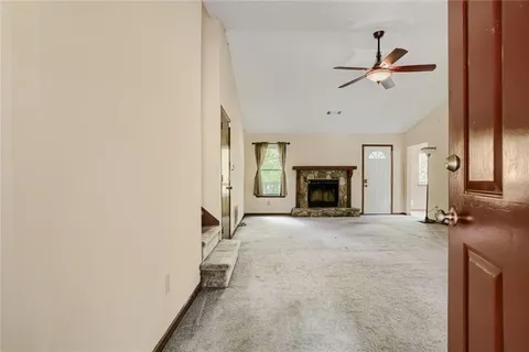 a view of a livingroom with fireplace and window
