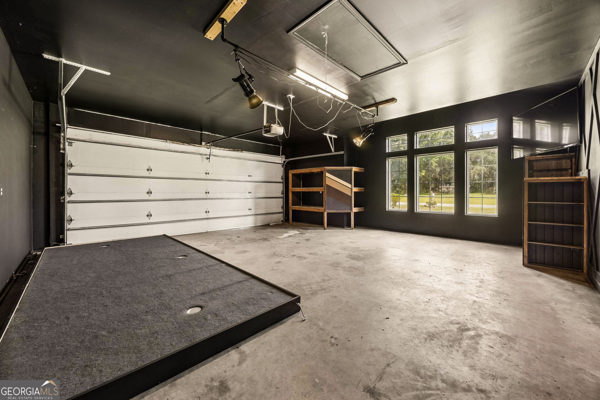 706 Hopewell Point Road White Oak, GA 31568 - Photo 82 of 84 Large garage with high ceilings, abundant space, and flexibility for multiple uses, showcasing custom finishes, built-in shelving, and exceptional storage potential.