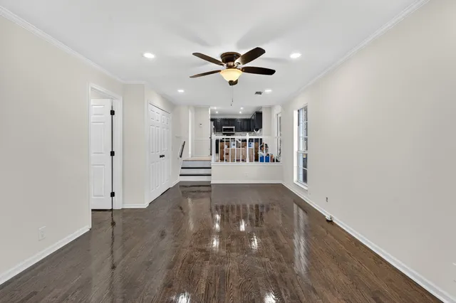 a view of an empty room with window and wooden floor
