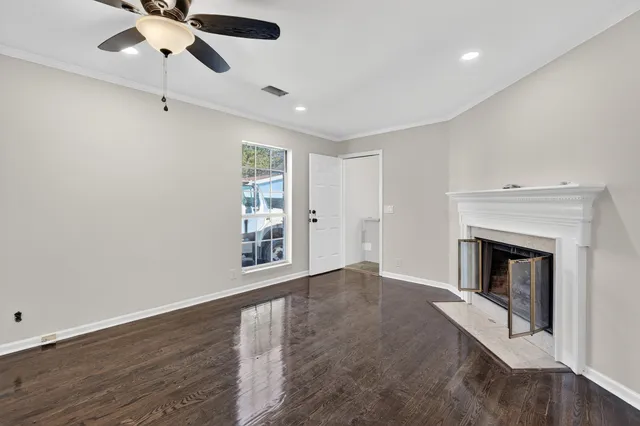 an empty room with windows fireplace and a sink