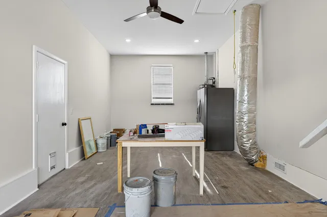a view of empty room with wooden floor and ceiling fan