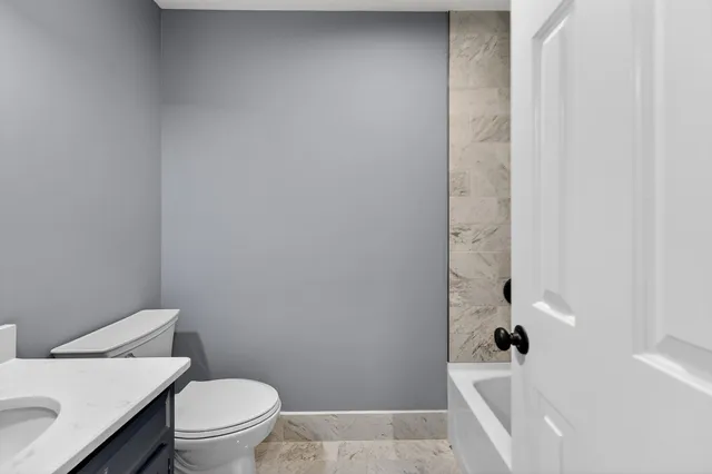 an empty room with wooden floor and ceiling fan