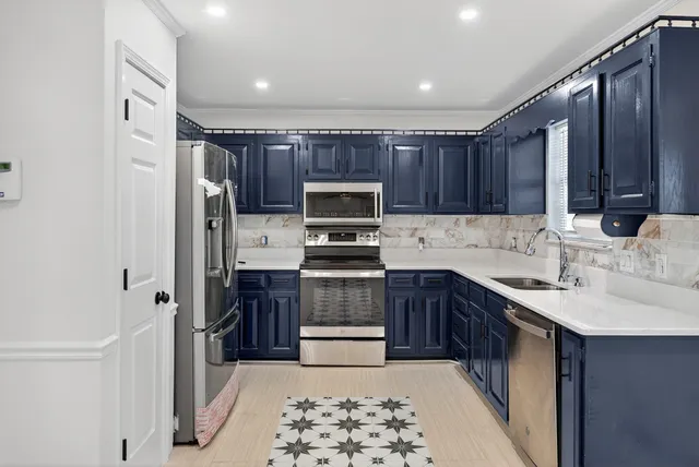a kitchen with a sink cabinets and stainless steel appliances