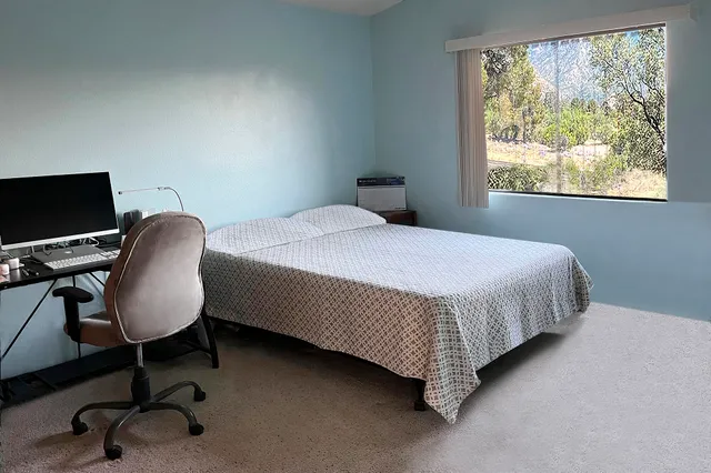 a bedroom with a bed chair and a window