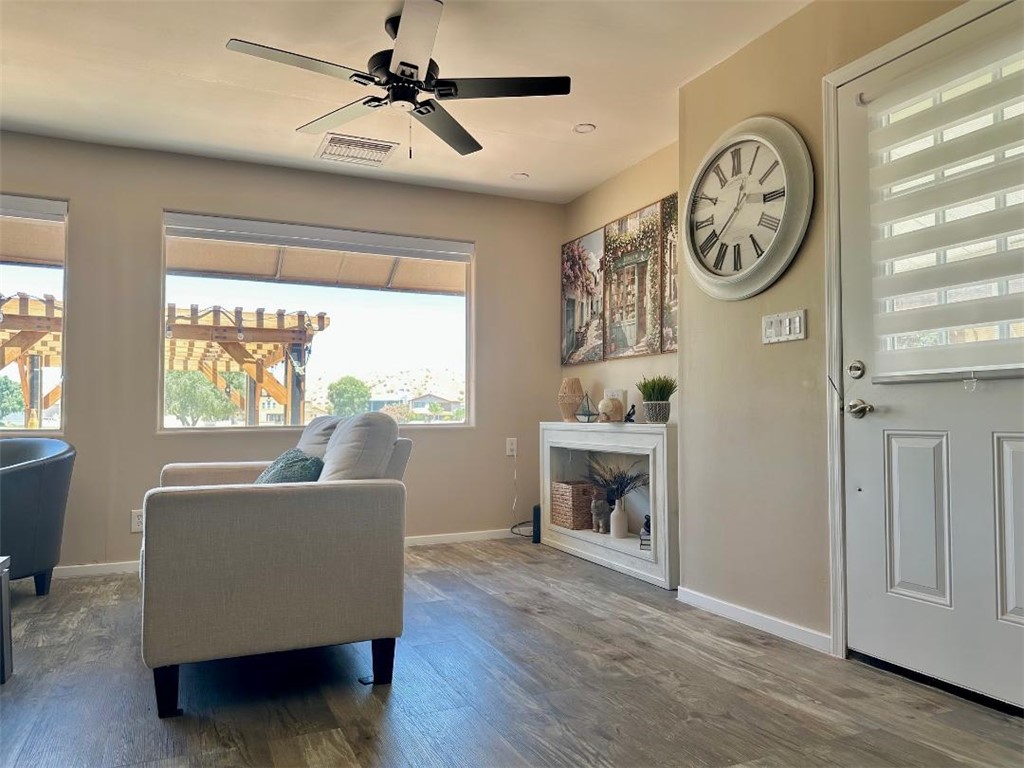 1395 Lause Road Bullhead City, AZ 86442 - Photo 5 of 34 Open-concept living area featuring wood-finish flooring, a contemporary ceiling fan, and large windows with integrated blinds