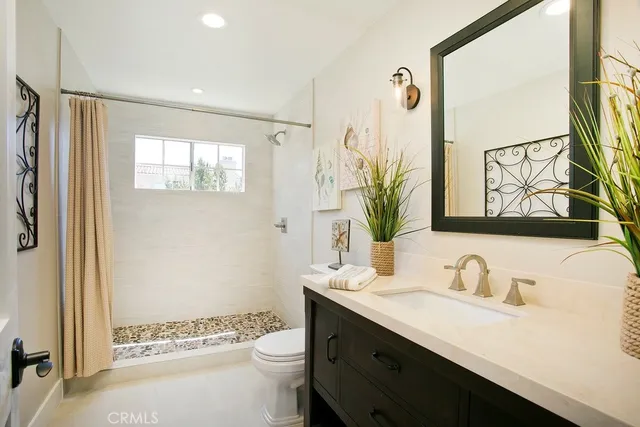 a bathroom with a granite countertop sink toilet and shower