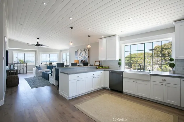 a large white kitchen with lots of counter space a sink and appliances