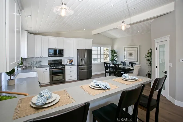 a kitchen that has stainless steel appliances a table and chairs