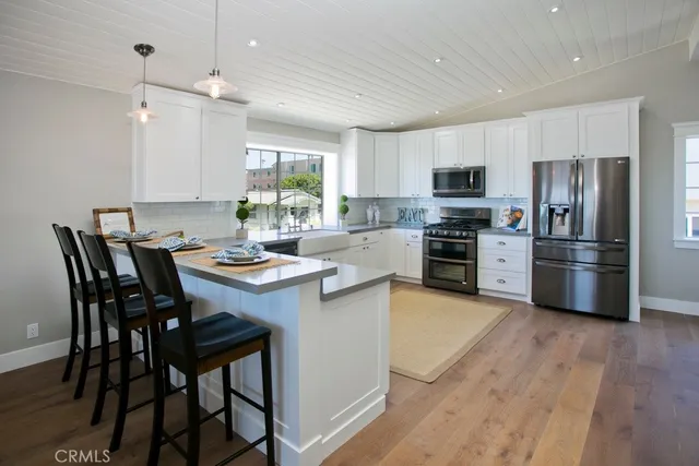 a kitchen with stainless steel appliances a stove a sink a dining table and chairs