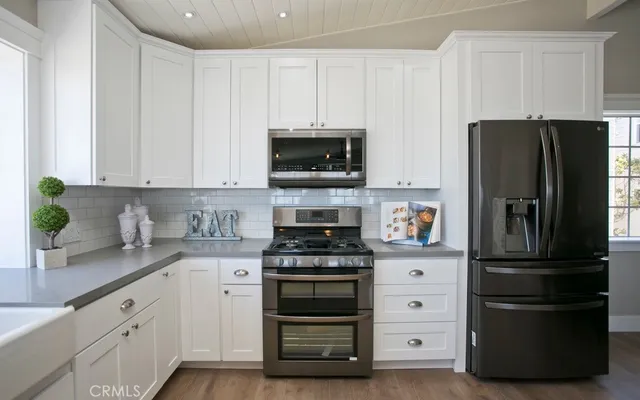 a kitchen with white cabinets and stainless steel appliances