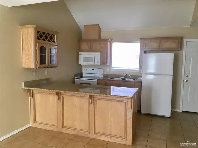 a kitchen with stainless steel appliances granite countertop a refrigerator a stove and a sink