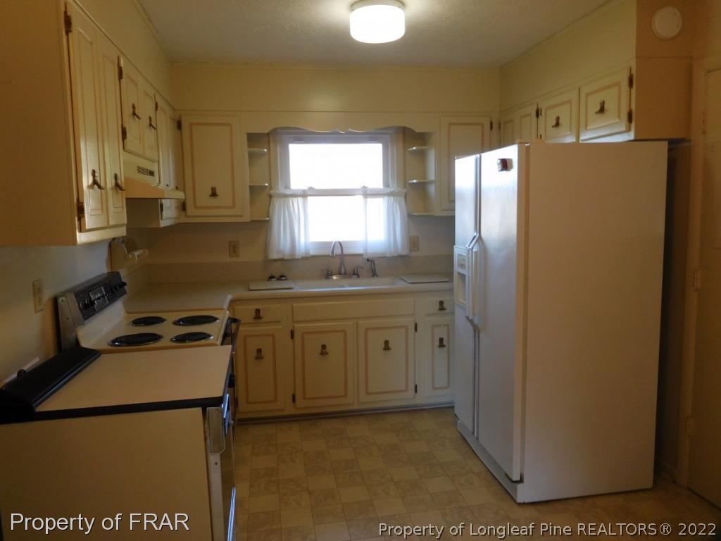 7449 Rockfish Road Raeford, NC 28376 - Photo 8 of 24 a kitchen with a refrigerator sink stove and cabinets