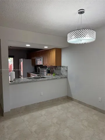 a kitchen with stainless steel appliances granite countertop a sink a stove and a refrigerator