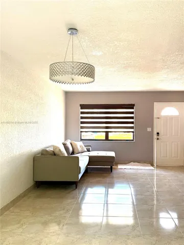 a living room with a couch and chandelier