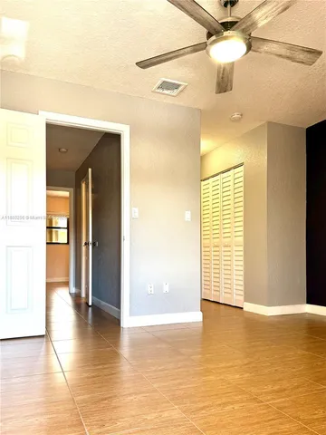 a view of a big room with a chandelier fan and windows