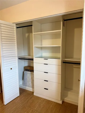a view of walk in closet with empty racks