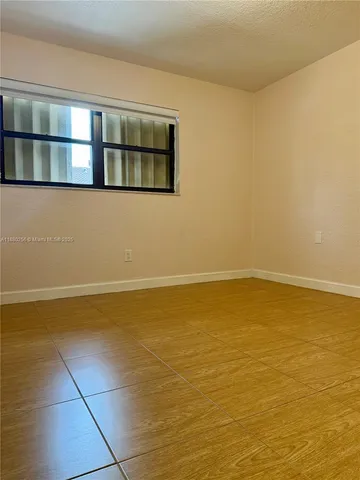 a view of a room with wooden floor and a window