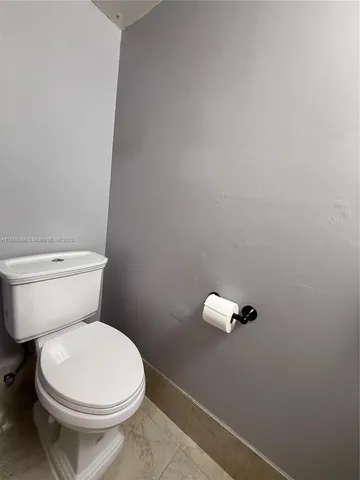 a white toilet sitting next to a shower