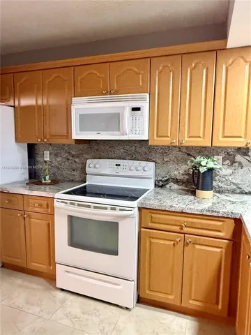 a kitchen with white cabinets sink and white stainless steel appliances