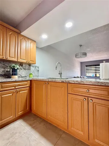 a kitchen with granite countertop a sink and cabinets