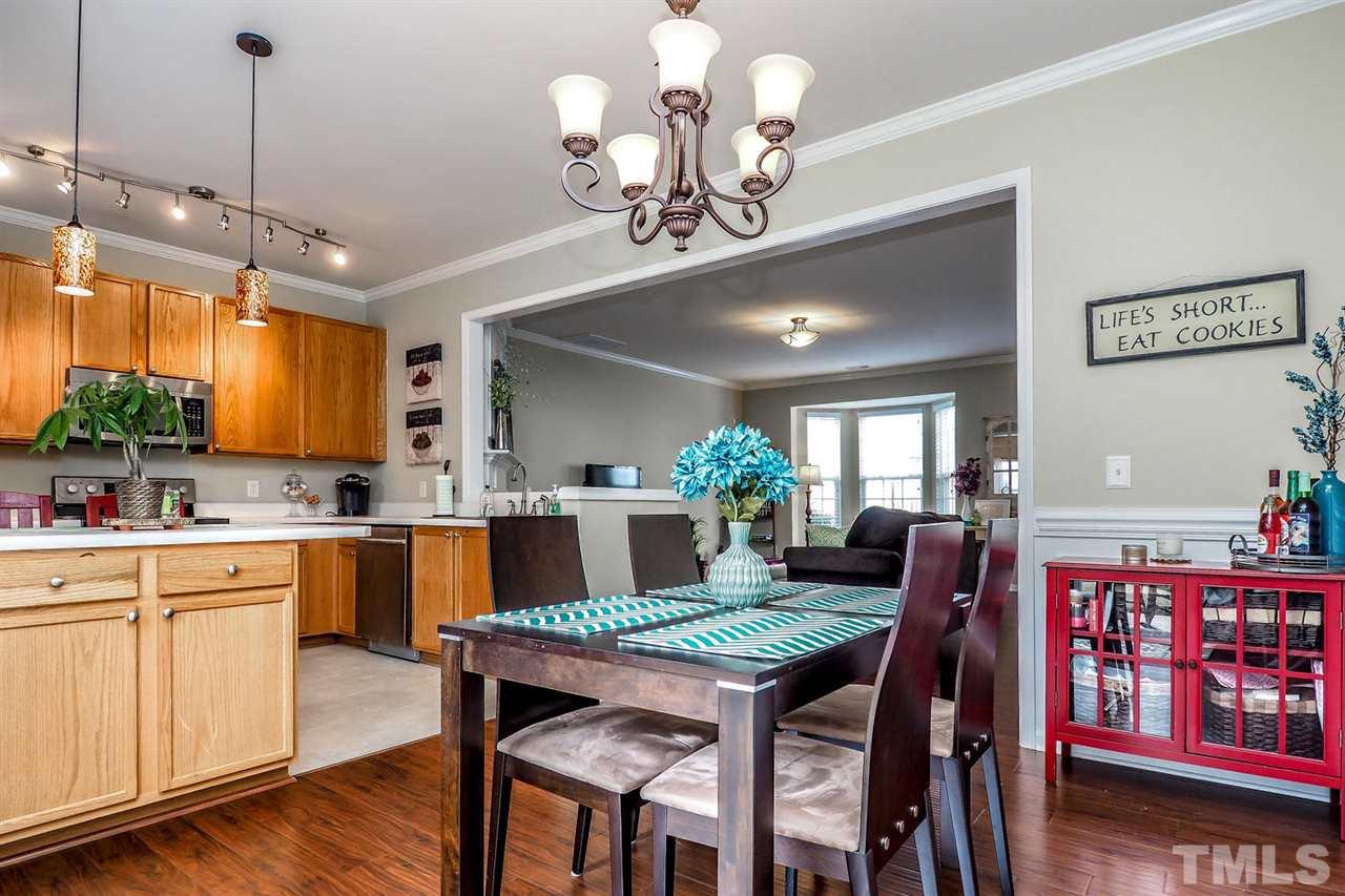 8205 Rhiannon Road Raleigh, NC 27613 - Photo 10 of 23 a view of a dining room with furniture window and wooden floor