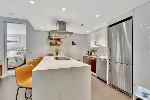 a kitchen with kitchen island and stainless steel appliances