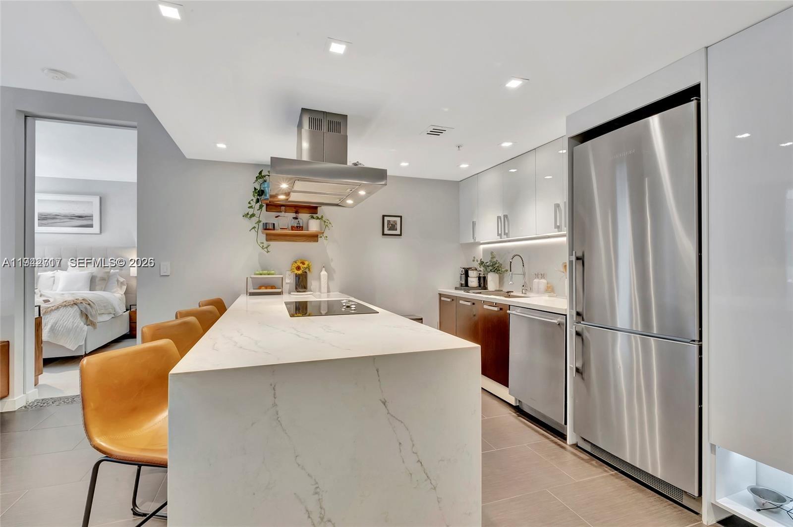 720 Northeast 62nd Street, Unit 307 Miami, FL 33138 - Photo 11 of 25 a kitchen with kitchen island and stainless steel appliances