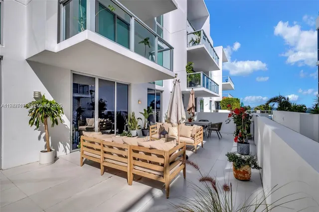 a view of a patio with couches and table and chairs with potted plants