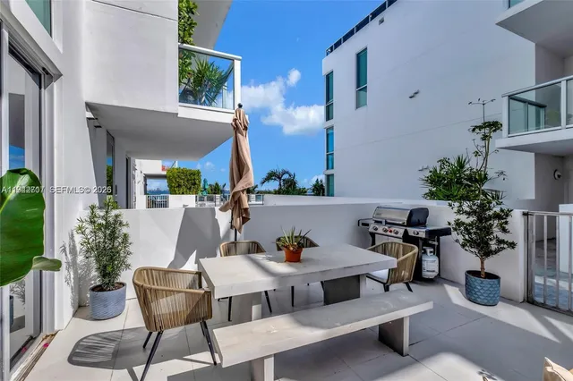 a view of a patio with table and chairs potted plants