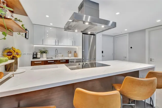a kitchen with stainless steel appliances granite countertop a sink a stove and a refrigerator