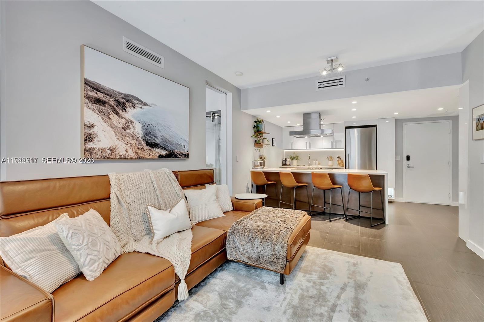 720 Northeast 62nd Street, Unit 307 Miami, FL 33138 - Photo 5 of 25 a living room with furniture and a couch