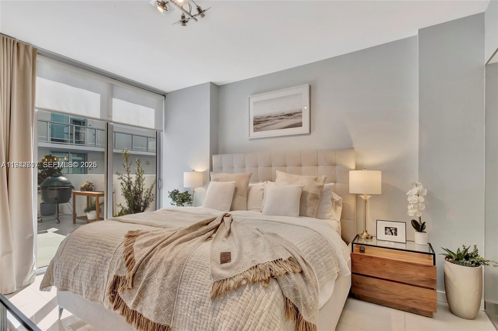 720 Northeast 62nd Street, Unit 307 Miami, FL 33138 - Photo 6 of 25 a bedroom with double bed and a potted plant