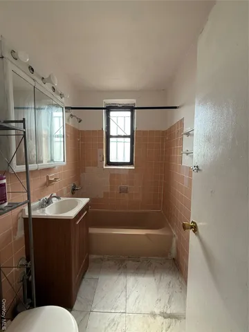 a bathroom with a sink toilet vanity and tub