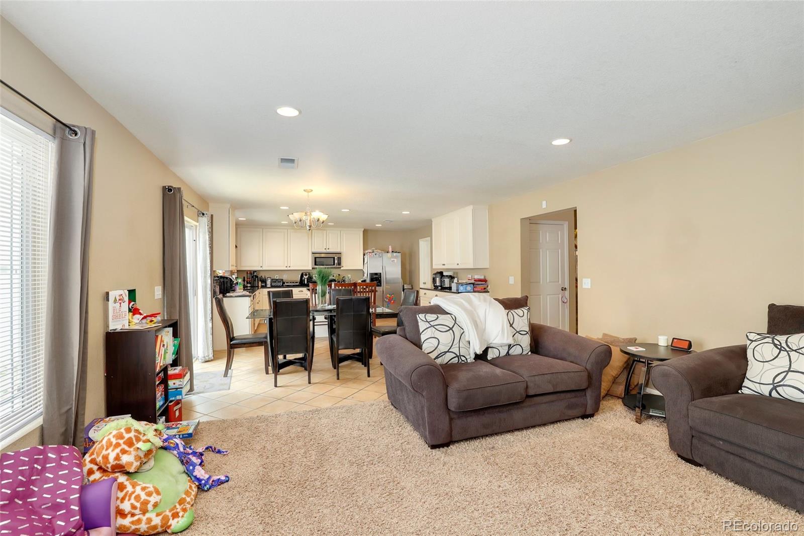 5380 Liverpool Street Denver, CO 80249 - Photo 12 of 30 a living room with furniture and a chandelier