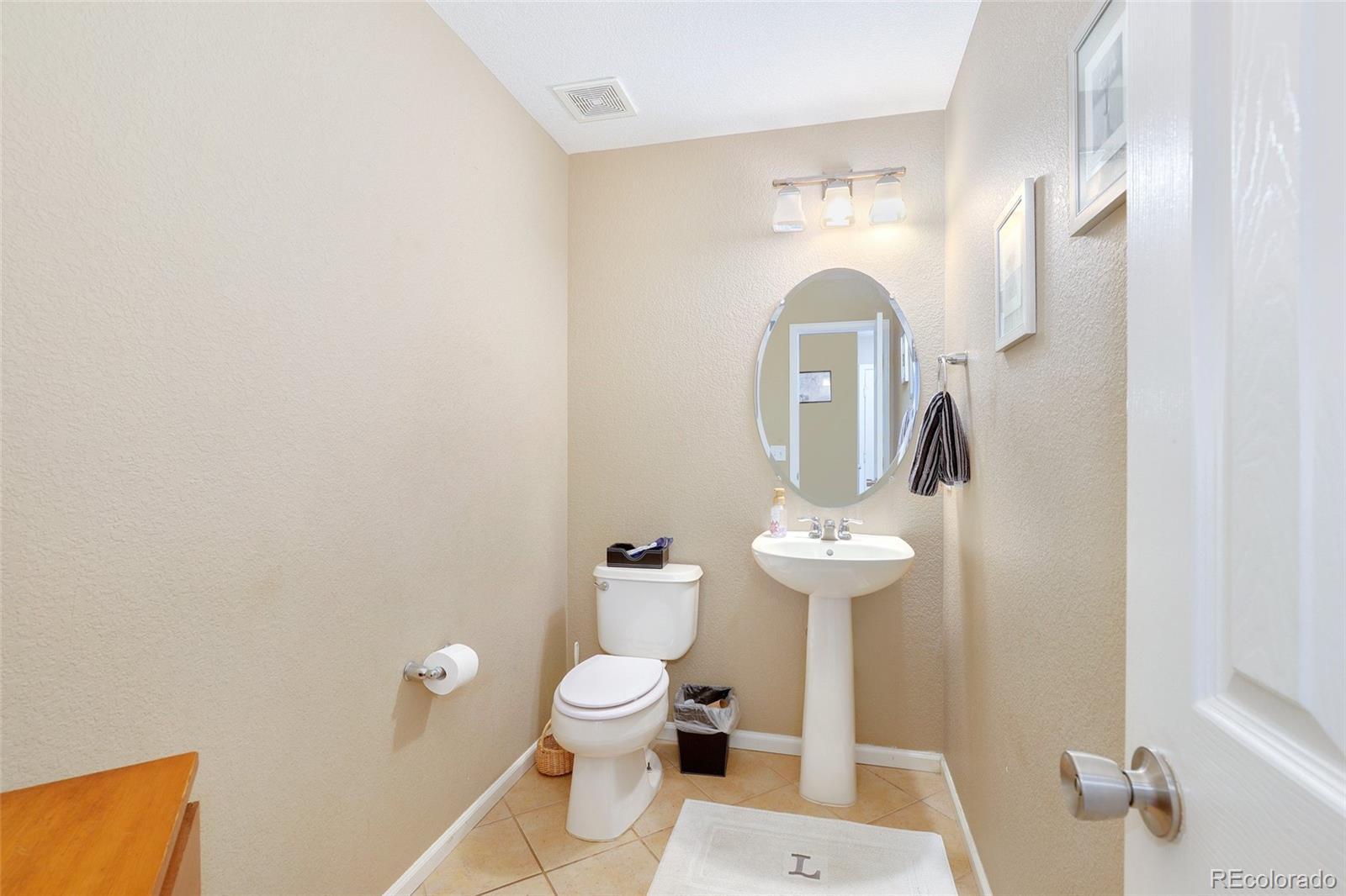 5380 Liverpool Street Denver, CO 80249 - Photo 13 of 30 a bathroom with a toilet sink and mirror