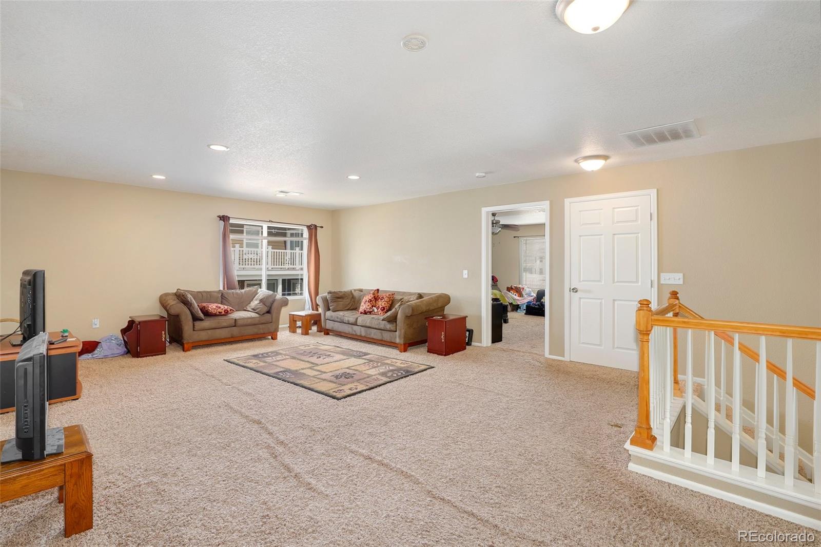 5380 Liverpool Street Denver, CO 80249 - Photo 15 of 30 a large bedroom with bed tv and window