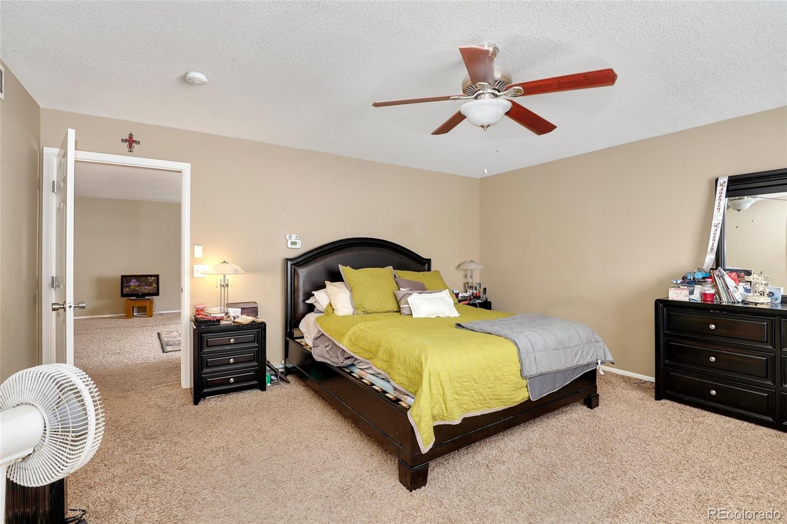 5380 Liverpool Street Denver, CO 80249 - Photo 17 of 30 a spacious bedroom with a bed and a chandelier