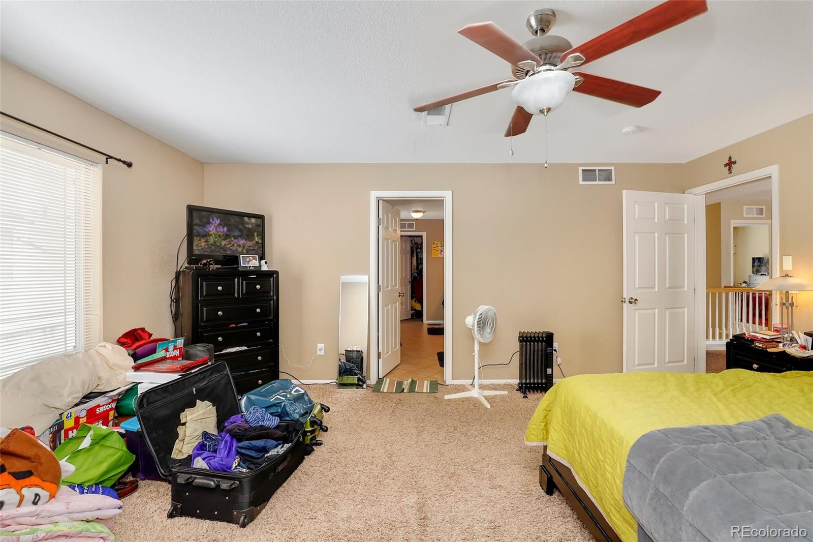 5380 Liverpool Street Denver, CO 80249 - Photo 19 of 30 a bedroom with a bed and a chandelier