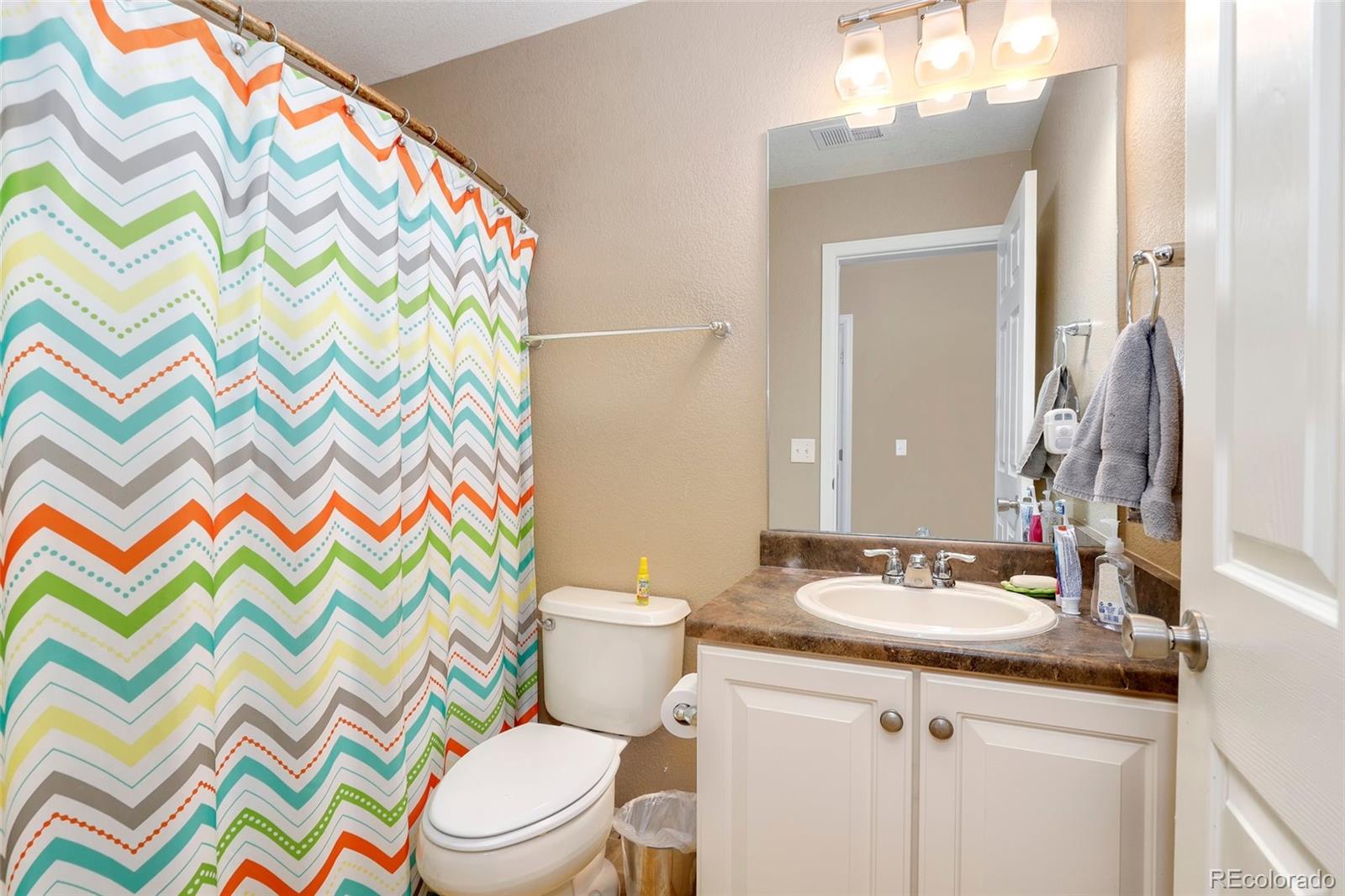 5380 Liverpool Street Denver, CO 80249 - Photo 25 of 30 a bathroom with a sink toilet and a mirror