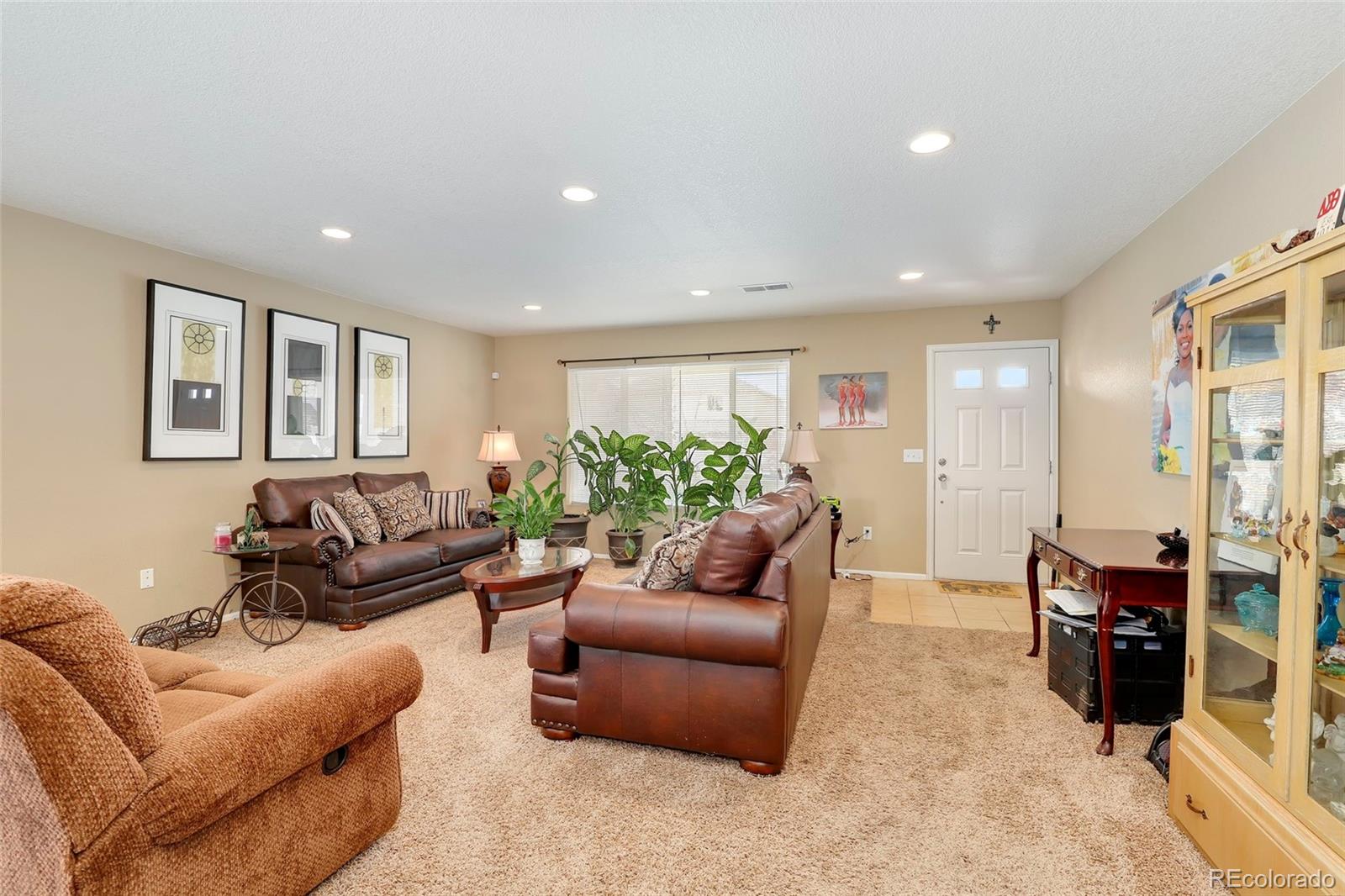 5380 Liverpool Street Denver, CO 80249 - Photo 3 of 30 a living room with furniture and a flat screen tv