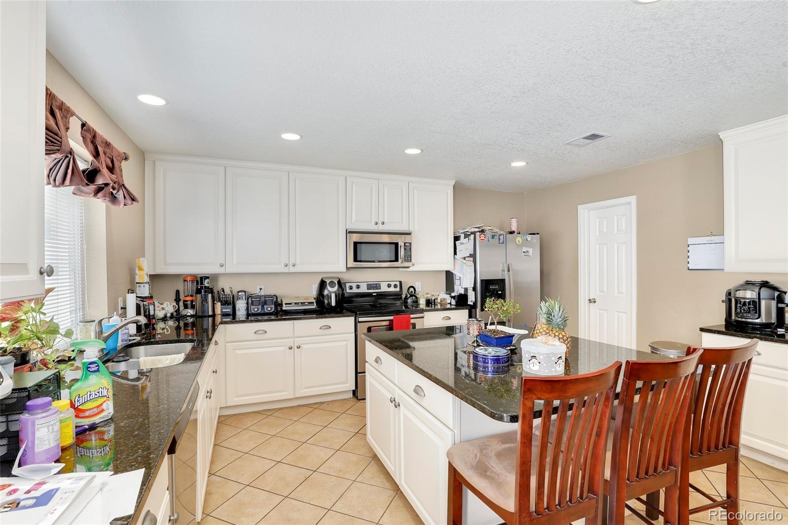 5380 Liverpool Street Denver, CO 80249 - Photo 9 of 30 a kitchen with granite countertop lots of counter top space