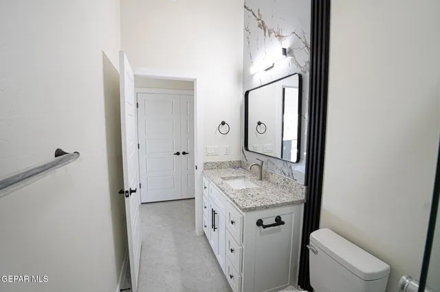 a bathroom with a granite countertop sink and a mirror