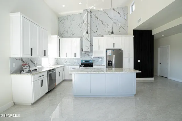 a large kitchen with cabinets and stainless steel appliances