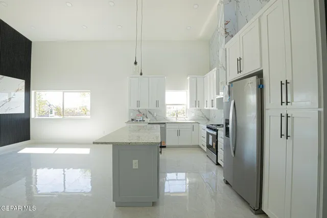 a kitchen with stainless steel appliances a refrigerator sink and stove