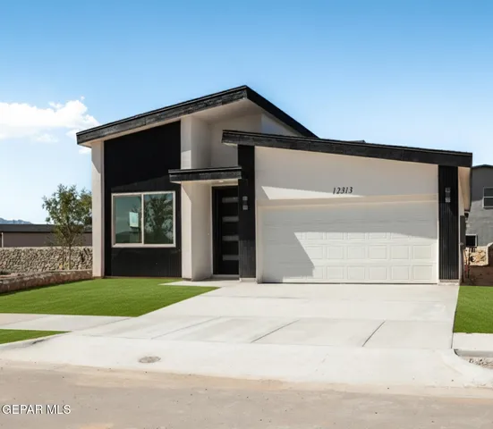 a front view of a house with a garden and garage