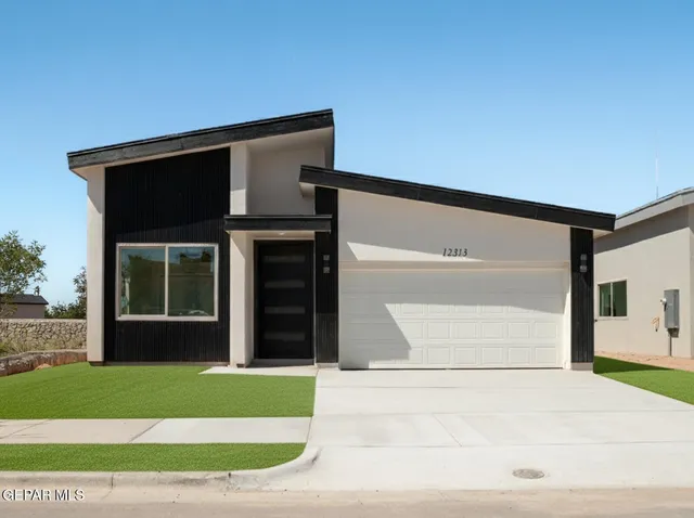 a view of a house with a yard and a garage