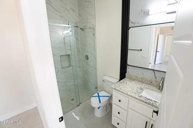 a bathroom with a granite countertop sink toilet and shower